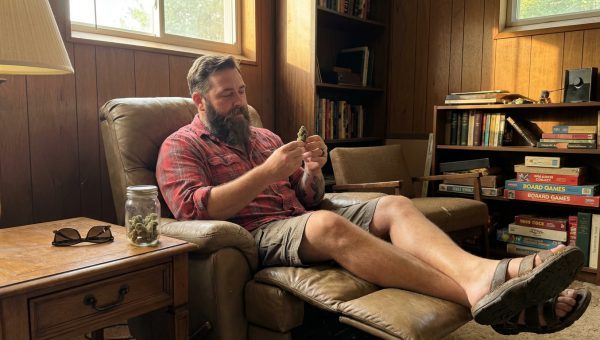Travis Cole examining Gelato cannabis buds in a relaxed setting