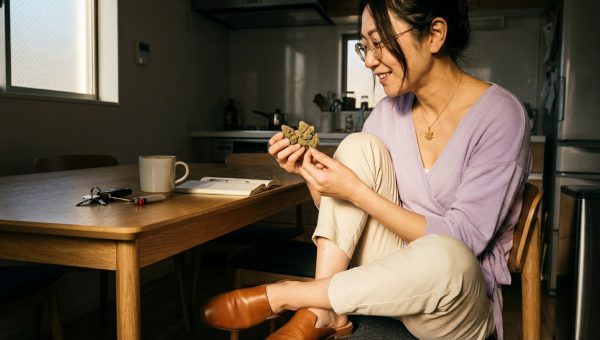 Maya Chen examining Gorilla Glue cannabis buds in a relaxed setting